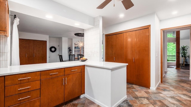 4171 Clotts Rd, Columbus, OH 43230 - kitchen featuring stone tile flooring, ceiling fan, brown cabinetry, baseboards, and light stone countertops