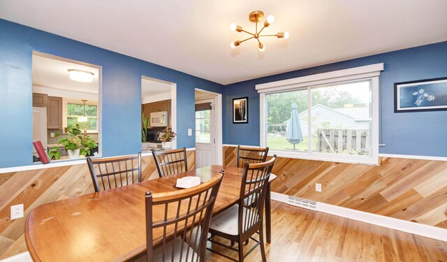 114 Highland Ave, Worthington, OH 43085 - dining space with a chandelier, light wood-style floors, wainscoting, and baseboards