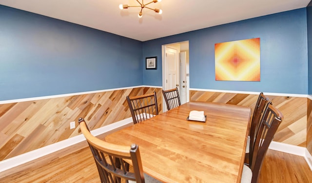 114 Highland Ave, Worthington, OH 43085 - dining area with a chandelier, wood finished floors, wooden walls, and baseboards