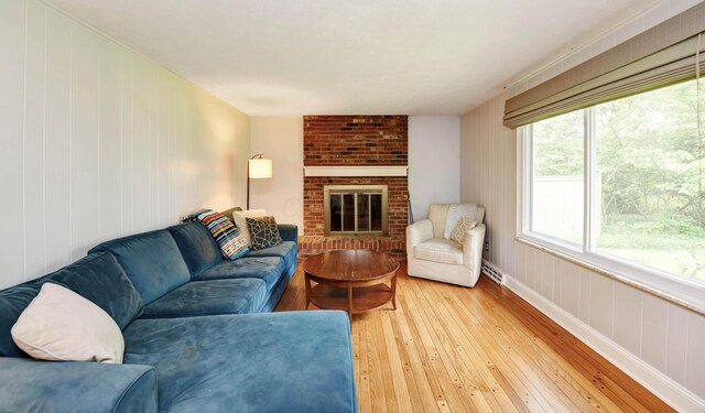 114 Highland Ave, Worthington, OH 43085 - living room featuring light wood-type flooring, a brick fireplace, baseboards, and wooden walls