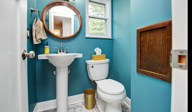 114 Highland Ave, Worthington, OH 43085 - bathroom with toilet, baseboards, and marble look tiles