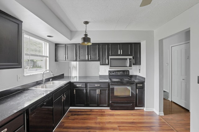 6446 Berry Pond Way, Canal Winchester, OH 43110 - kitchen featuring black appliances, a sink, light wood finished floors, a textured ceiling, and dark countertops