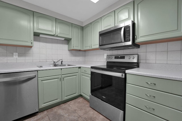 1508 Ives Ave, Reynoldsburg, OH 43068 - kitchen with green cabinetry, appliances with stainless steel finishes, a sink, and light countertops