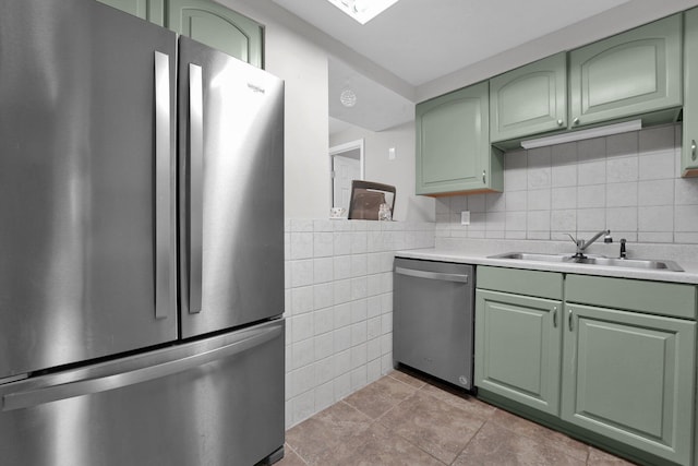 1508 Ives Ave, Reynoldsburg, OH 43068 - kitchen featuring appliances with stainless steel finishes, green cabinets, a sink, light countertops, and tile walls