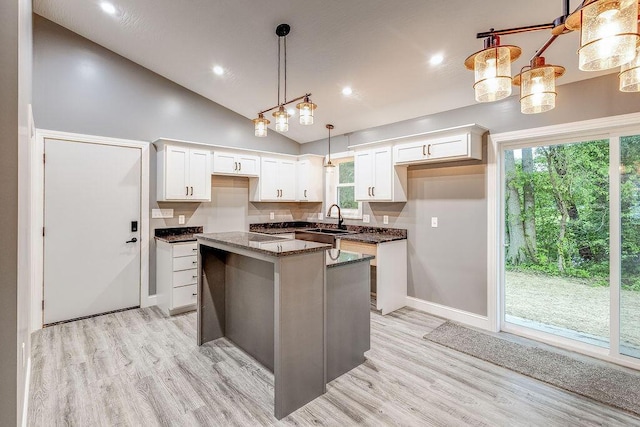 228 E Walnut St, Danville, OH 43014 - kitchen featuring a sink, a kitchen island, white cabinetry, light wood-type flooring, and vaulted ceiling