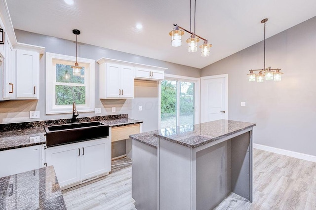 228 E Walnut St, Danville, OH 43014 - kitchen featuring a sink, light wood finished floors, white cabinetry, a kitchen island, and lofted ceiling
