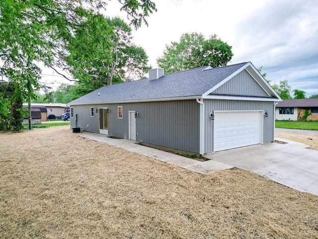 228 E Walnut St, Danville, OH 43014 - view of front of home with an attached garage, concrete driveway, a chimney, a shingled roof, and cooling unit