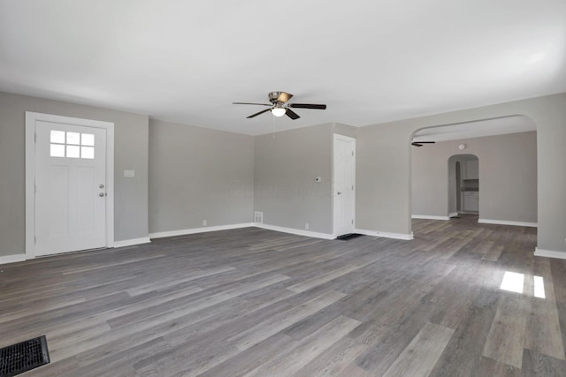 901 E Vine St, Mount Vernon, OH 43050 - unfurnished living room with a ceiling fan, arched walkways, wood finished floors, and baseboards