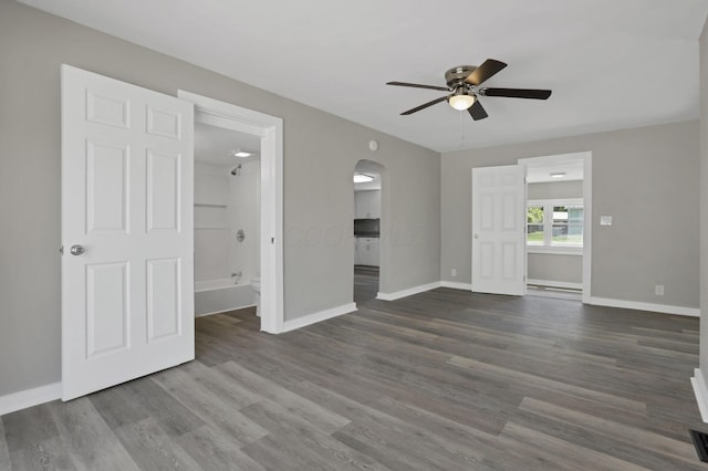 901 E Vine St, Mount Vernon, OH 43050 - empty room with arched walkways, ceiling fan, baseboards, and dark wood-style flooring