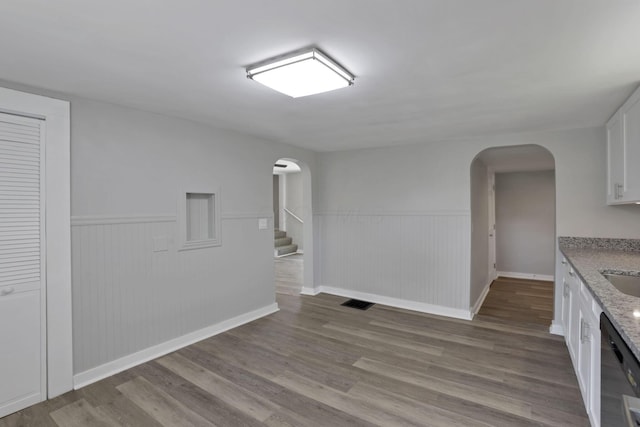 901 E Vine St, Mount Vernon, OH 43050 - interior space with arched walkways, wood finished floors, a wainscoted wall, stairway, and baseboards