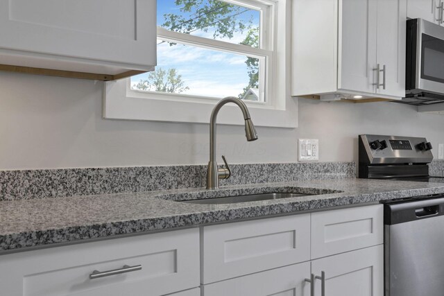 901 E Vine St, Mount Vernon, OH 43050 - kitchen featuring appliances with stainless steel finishes, a sink, and white cabinetry