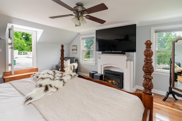 2738 E Broad St, Columbus, OH 43209 - bedroom with multiple windows, a warm lit fireplace, wood finished floors, ceiling fan, and vaulted ceiling