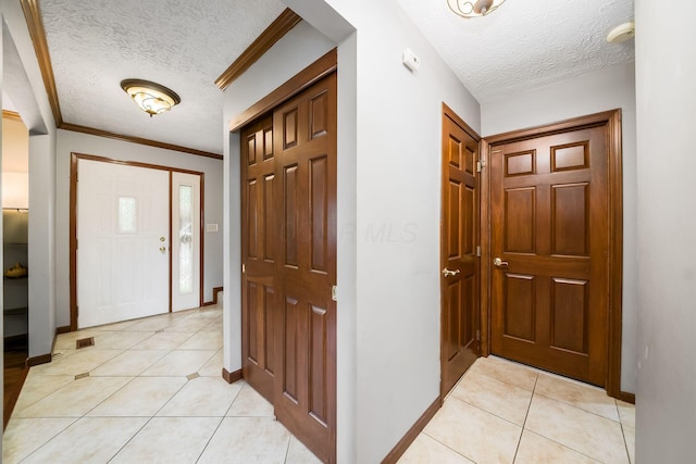 2862 Shady Ridge Dr, Columbus, OH 43231 - entryway featuring a textured ceiling, light tile patterned floors, baseboards, and ornamental molding