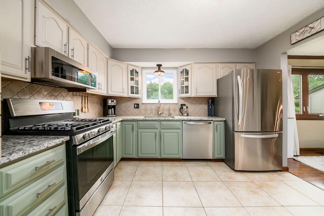 2862 Shady Ridge Dr, Columbus, OH 43231 - kitchen featuring appliances with stainless steel finishes, green cabinets, a sink, healthy amount of natural light, and a textured ceiling