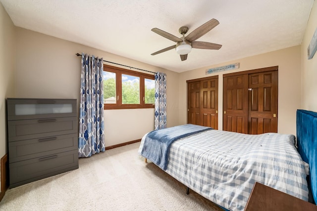 2862 Shady Ridge Dr, Columbus, OH 43231 - bedroom featuring light colored carpet, two closets, baseboards, and a ceiling fan