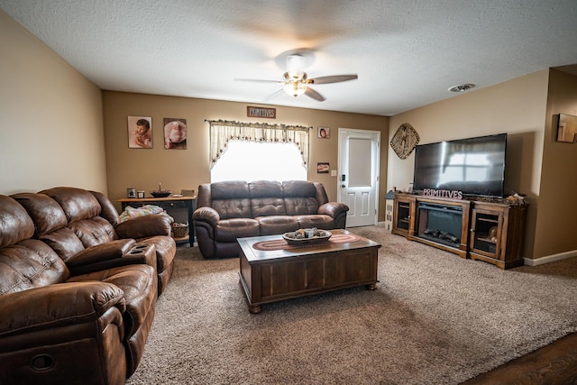 2025 Little Creek Rd, Frankfort, OH 45628 - carpeted living area with ceiling fan, plenty of natural light, a textured ceiling, and a glass covered fireplace
