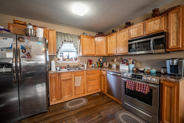 2025 Little Creek Rd, Frankfort, OH 45628 - kitchen with stainless steel appliances, a sink, dark wood-style flooring, a textured ceiling, and dark countertops
