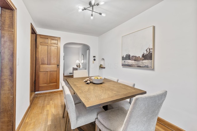 157 E Dominion Blvd, Columbus, OH 43214 - dining area with arched walkways, light wood-type flooring, a chandelier, and baseboards