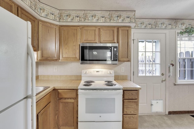 2294 Perkins Ct, Columbus, OH 43229 - kitchen featuring white appliances, light countertops, and light carpet