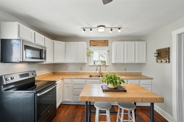 11725 Old Columbus Rd, South Vienna, OH 45369 - kitchen featuring stainless steel microwave, electric stove, light countertops, and white cabinetry