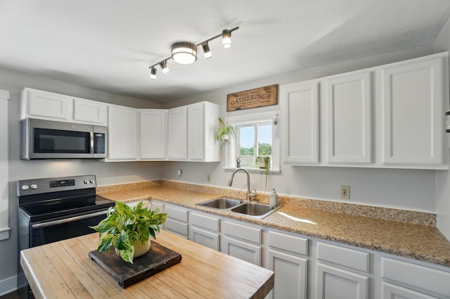 11725 Old Columbus Rd, South Vienna, OH 45369 - kitchen featuring stainless steel appliances, a sink, and white cabinetry