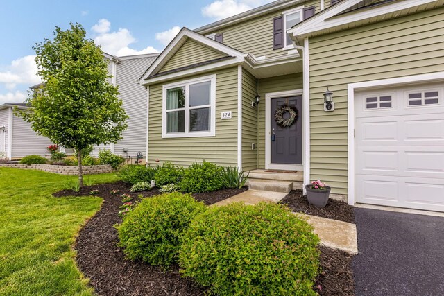324 Raccoon Ave, Johnstown, OH 43031 - view of exterior entry featuring a garage and a lawn