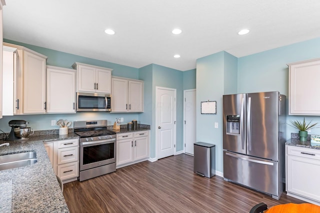 324 Raccoon Ave, Johnstown, OH 43031 - kitchen with appliances with stainless steel finishes, dark wood-type flooring, stone countertops, a sink, and white cabinets