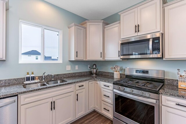 324 Raccoon Ave, Johnstown, OH 43031 - kitchen featuring stainless steel appliances, a sink, dark stone countertops, dark wood finished floors, and white cabinetry