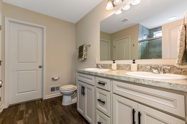 324 Raccoon Ave, Johnstown, OH 43031 - bathroom with a stall shower, toilet, double vanity, wood finished floors, and baseboards