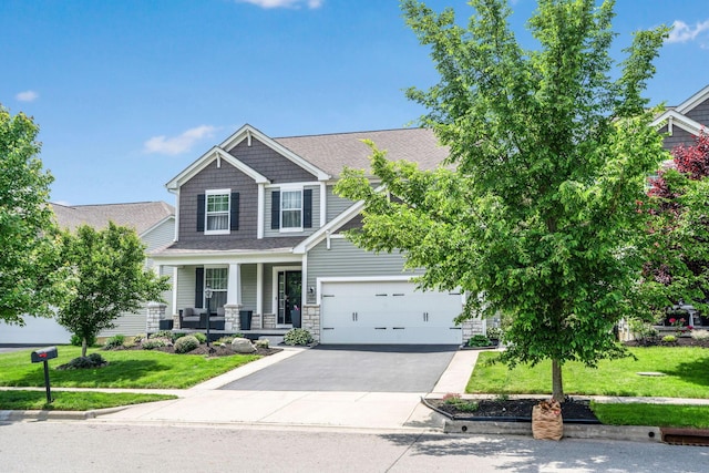 2991 Green Line Way, Columbus, OH 43231 - craftsman-style house with covered porch, a front lawn, asphalt driveway, and a garage