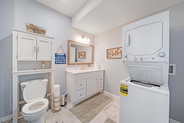 2991 Green Line Way, Columbus, OH 43231 - bathroom with stacked washer and clothes dryer, marble finish floors, vanity, toilet, and baseboards