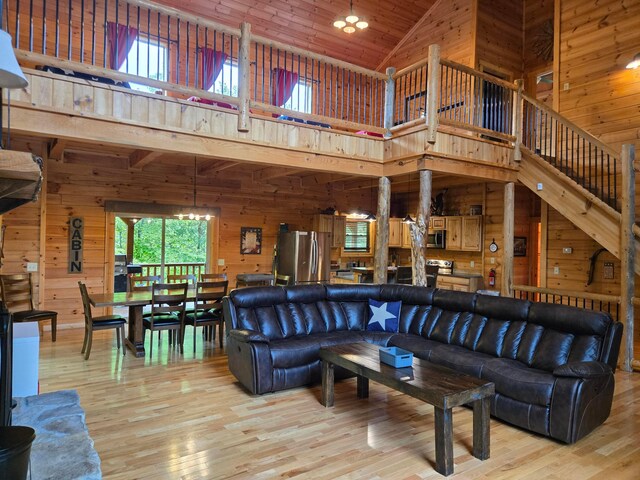 21760 State Route 93, Logan, OH 43138 - living room featuring wooden walls, high vaulted ceiling, light wood-style floors, and stairway