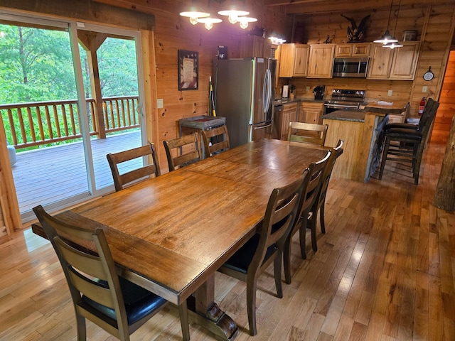 21760 State Route 93, Logan, OH 43138 - dining area featuring wood walls, a chandelier, and light wood-type flooring