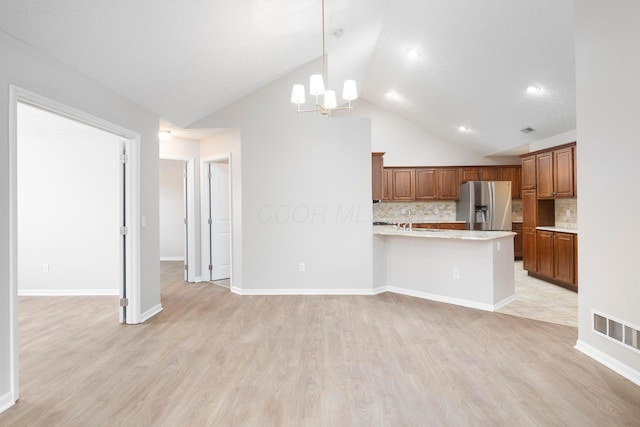 6174 Brickside Dr, New Albany, OH 43054 - kitchen featuring stainless steel refrigerator with ice dispenser, brown cabinets, light countertops, backsplash, and a chandelier