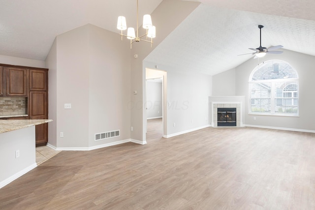 6174 Brickside Dr, New Albany, OH 43054 - unfurnished living room with vaulted ceiling, light wood finished floors, ceiling fan, a chandelier, and a fireplace