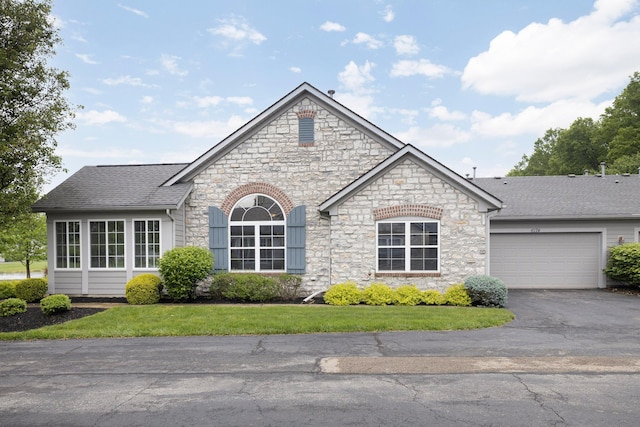 6174 Brickside Dr, New Albany, OH 43054 - french country home featuring stone siding, driveway, a garage, and a front yard