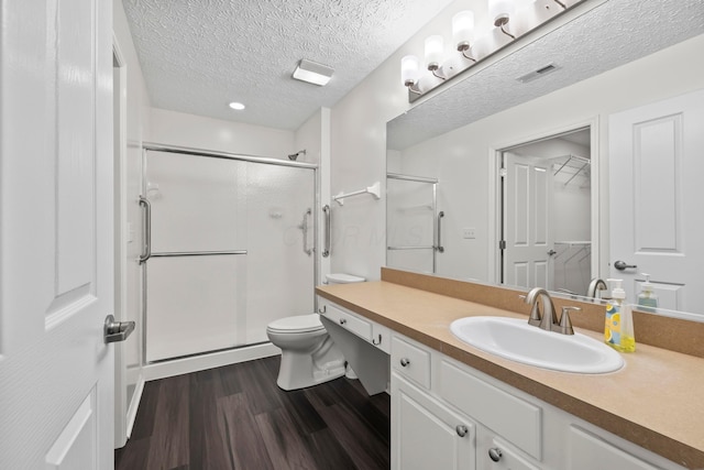 143 Falls Peak Ln, Delaware, OH 43015 - bathroom with wood finished floors, a shower stall, vanity, toilet, and a textured ceiling