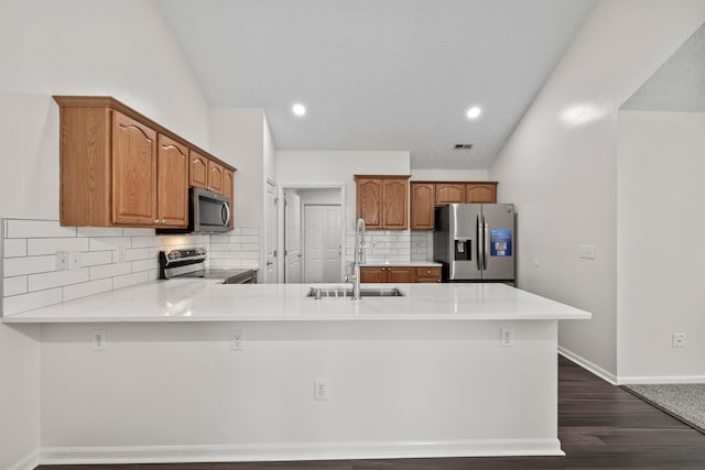 143 Falls Peak Ln, Delaware, OH 43015 - kitchen with stainless steel appliances, a sink, a peninsula, dark wood-type flooring, and backsplash