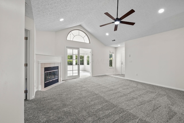 143 Falls Peak Ln, Delaware, OH 43015 - unfurnished living room featuring ceiling fan, carpet flooring, a tile fireplace, baseboards, and a textured ceiling