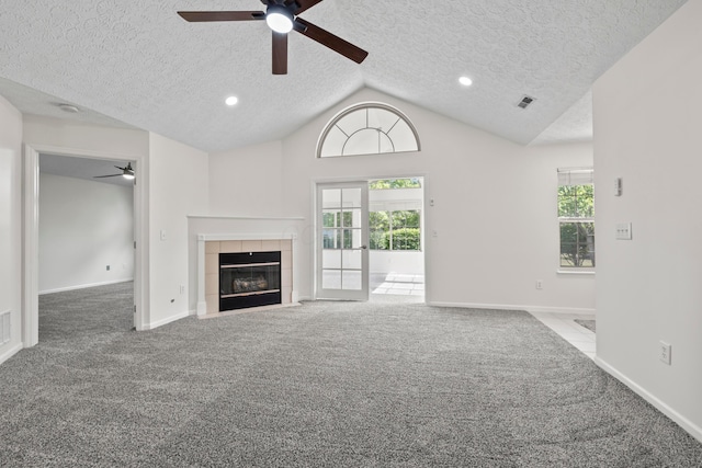 143 Falls Peak Ln, Delaware, OH 43015 - unfurnished living room featuring a ceiling fan, carpet flooring, a textured ceiling, a tile fireplace, and lofted ceiling