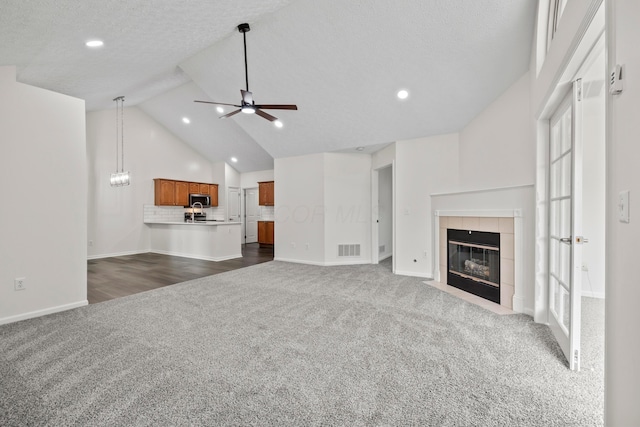 143 Falls Peak Ln, Delaware, OH 43015 - unfurnished living room with dark carpet, baseboards, a ceiling fan, high vaulted ceiling, and a fireplace