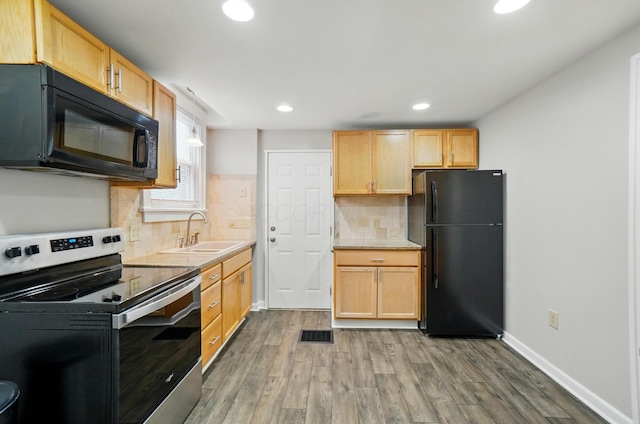 1146 Walters St, Columbus, OH 43201 - kitchen with black appliances, a sink, wood finished floors, recessed lighting, and light countertops
