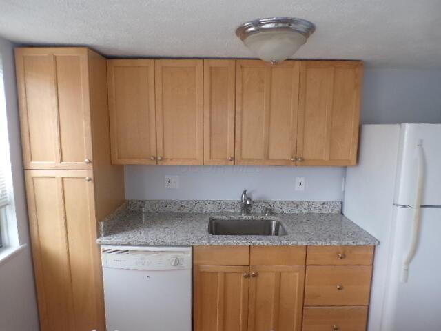 1022 Galliton Ct Unit C, Columbus, OH 43220 - kitchen with white appliances, a sink, light stone countertops, and a textured ceiling