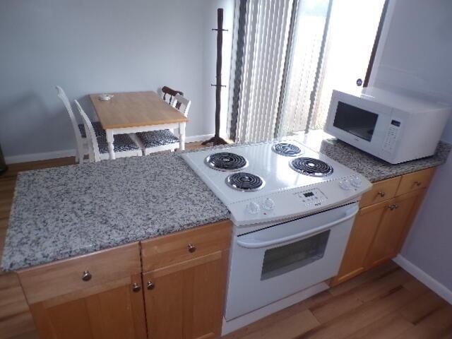 1022 Galliton Ct Unit C, Columbus, OH 43220 - kitchen featuring white appliances, light wood-style floors, light stone counters, and baseboards