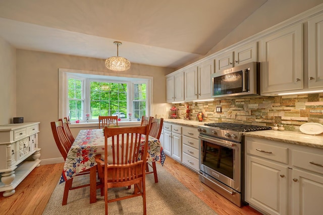 1494 Old Carriage Ct, Canal Winchester, OH 43110 - kitchen featuring appliances with stainless steel finishes, decorative backsplash, white cabinetry, light wood-type flooring, and lofted ceiling