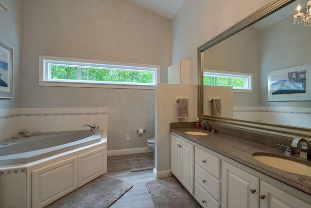 1494 Old Carriage Ct, Canal Winchester, OH 43110 - full bathroom featuring a garden tub, double vanity, toilet, wood finished floors, and a chandelier