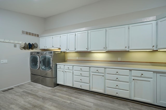 1494 Old Carriage Ct, Canal Winchester, OH 43110 - laundry area featuring washer and dryer, cabinet space, and light wood-type flooring