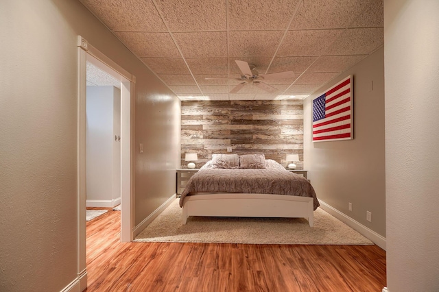 1494 Old Carriage Ct, Canal Winchester, OH 43110 - bedroom with wooden walls, wood finished floors, a paneled ceiling, baseboards, and a ceiling fan