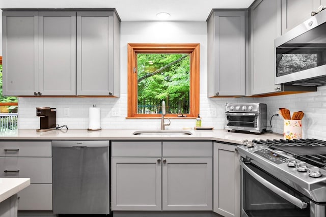 5528 Cypress Ct, Westerville, OH 43082 - kitchen featuring stainless steel appliances, gray cabinets, a sink, and backsplash