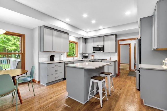 5528 Cypress Ct, Westerville, OH 43082 - kitchen featuring appliances with stainless steel finishes, gray cabinetry, decorative backsplash, light wood finished floors, and recessed lighting